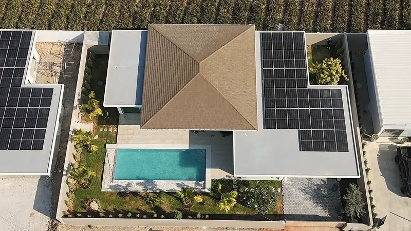Aerial view of a villa under construction, with solar panels